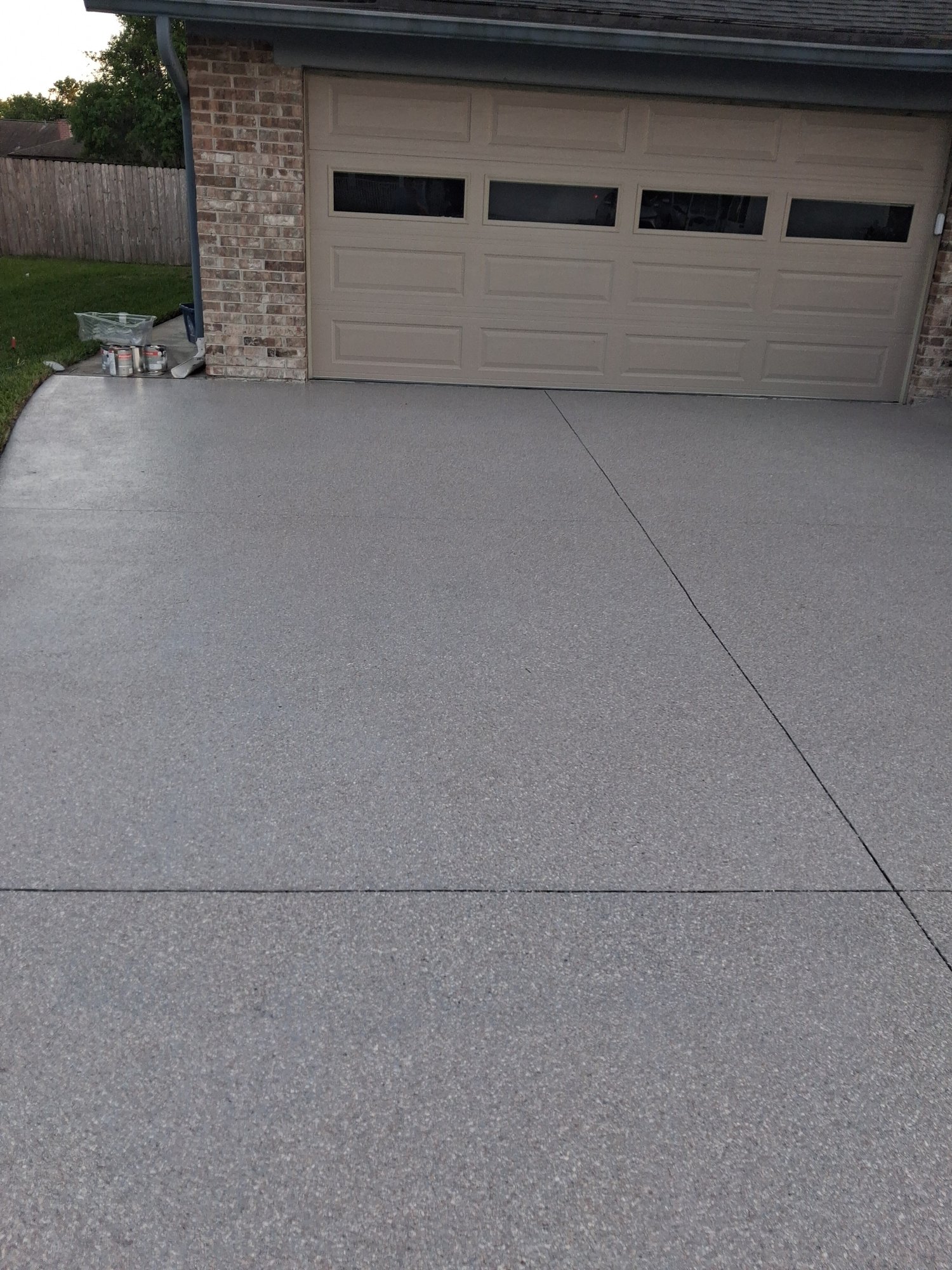 Wide grey flake double driveway leading up to a 2-car garage